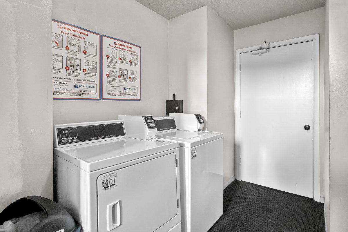 A laundry room with two washers and two dryers.